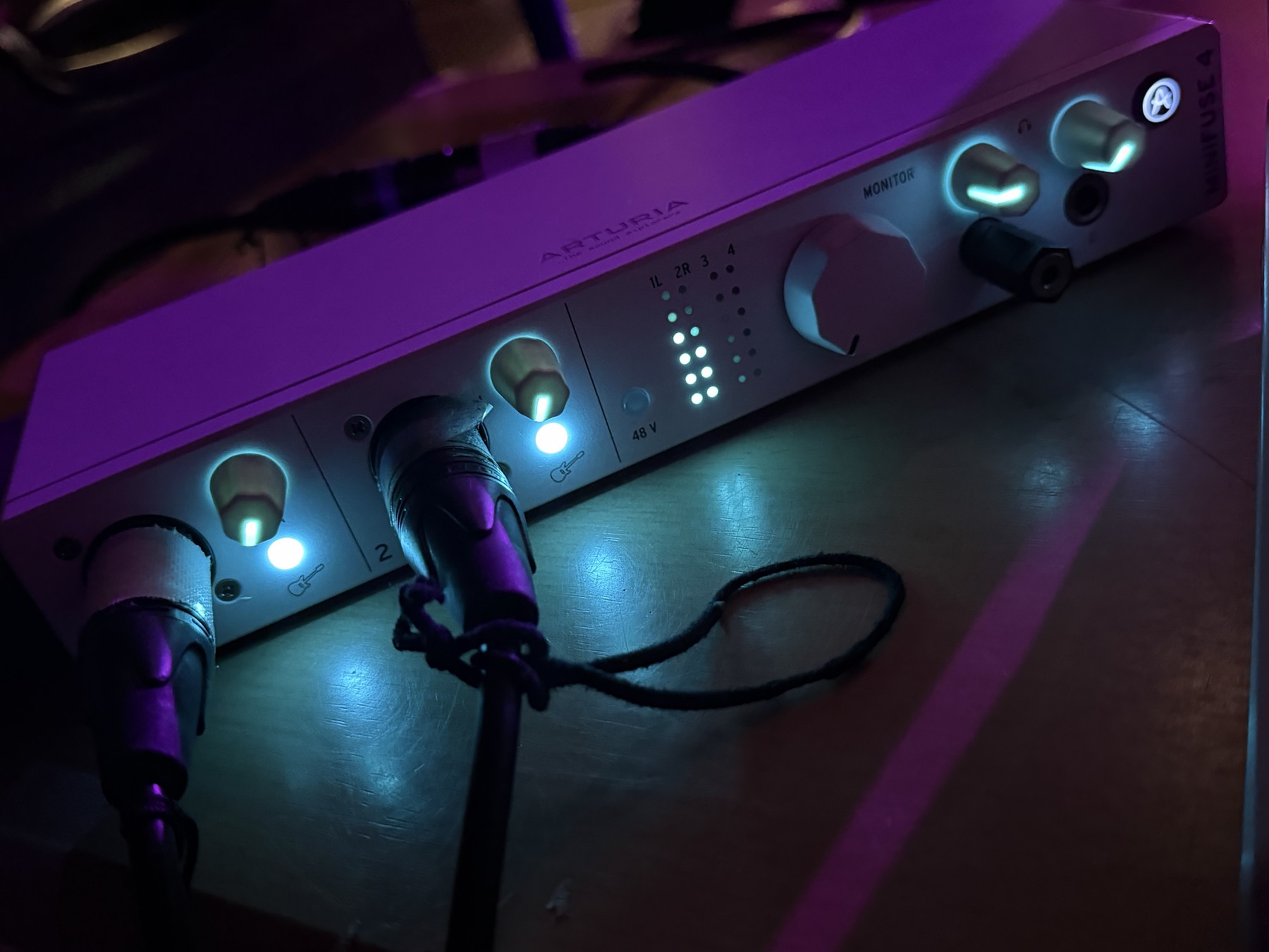 ケーブルを接続したARTURIA MiniFuse 4。紫と青の照明に照らされた録音環境